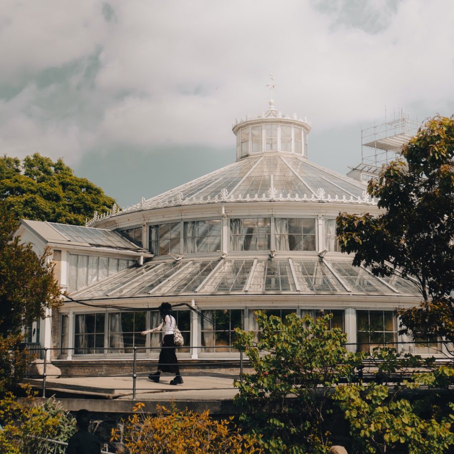 Frau geht vor Gewächshaus in Kopenhagen entlang