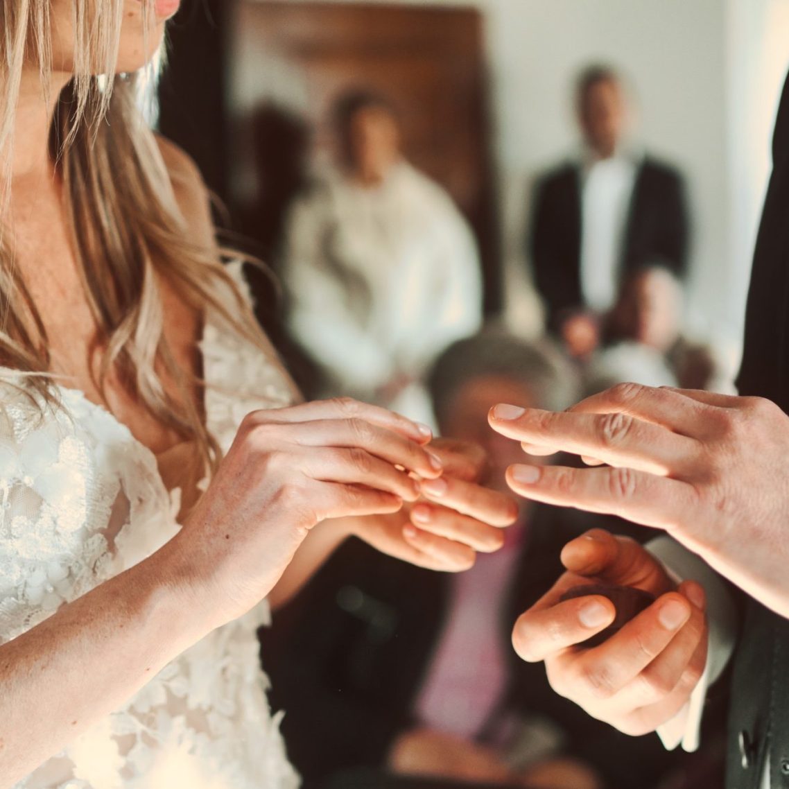 Die Braut steckt dem Bräutigam den Ring im Standesamt an den Finger