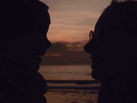Mutter und Tochter in filmischer kontrastreicher Pose am Strand